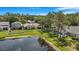 Aerial view of a serene backyard with a pond, mature trees, and lush greenery at 7031 Kendall Heath Way, Land O Lakes, FL 34637