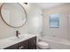 Well-lit bathroom featuring a vanity with sink, toilet, and a tiled bathtub with shower at 7031 Kendall Heath Way, Land O Lakes, FL 34637