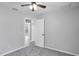 Neutral bedroom featuring ceiling fan, grey carpet, and an adjoining doorway for easy access at 7031 Kendall Heath Way, Land O Lakes, FL 34637