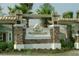 Stone monument marks entrance to Wilderness Lake community with mature palm trees and manicured landscaping at 7031 Kendall Heath Way, Land O Lakes, FL 34637