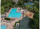 Aerial view of a community pool featuring a spa, tennis courts, and manicured landscaping at 7031 Kendall Heath Way, Land O Lakes, FL 34637