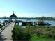 Scenic lake view with pier, gazebo, boat dock, and lush vegetation along the shoreline at 7031 Kendall Heath Way, Land O Lakes, FL 34637