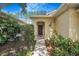 Charming home entrance with a well-kept garden and a lovely wooden front door at 7031 Kendall Heath Way, Land O Lakes, FL 34637