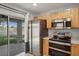 The kitchen features stainless steel appliances and a sliding door leading to an outdoor patio at 7031 Kendall Heath Way, Land O Lakes, FL 34637