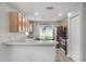 Kitchen with bar, wood cabinets, stainless steel refrigerator, and view to the back yard at 7031 Kendall Heath Way, Land O Lakes, FL 34637