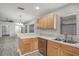 Bright kitchen featuring wooden cabinets, stainless steel dishwasher, and sink with a window at 7031 Kendall Heath Way, Land O Lakes, FL 34637