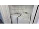 Convenient laundry area featuring a stacked washer and dryer and wire rack shelving for optimal storage at 7031 Kendall Heath Way, Land O Lakes, FL 34637