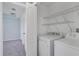 Bright laundry room with white washer, dryer, and wire shelving at 7031 Kendall Heath Way, Land O Lakes, FL 34637