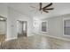 Bright and airy living room featuring wood-look floors, large windows, and a ceiling fan at 7031 Kendall Heath Way, Land O Lakes, FL 34637
