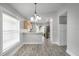 Open living room with wood floors, a view into the kitchen and the sliding glass doors to the backyard at 7031 Kendall Heath Way, Land O Lakes, FL 34637