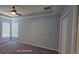 Spacious main bedroom with tray ceiling, ceiling fan, carpet flooring and natural light from windows at 7031 Kendall Heath Way, Land O Lakes, FL 34637