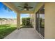 Covered patio with ceiling fan, leading to a fenced backyard with green grass at 7031 Kendall Heath Way, Land O Lakes, FL 34637