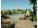 Resort-style pool area with lounge chairs, umbrellas, mature palm trees and lush landscaping at 7031 Kendall Heath Way, Land O Lakes, FL 34637
