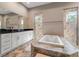 Luxurious bathroom with a large soaking tub between and walk-in showers, and double vanities at 7340 West Dr, Wesley Chapel, FL 33544