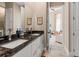 Bathroom with double sinks, granite countertops, white cabinetry, and ample mirror space at 7340 West Dr, Wesley Chapel, FL 33544