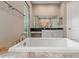 Soaking tub featuring stylish fixtures, countertops, and a walk-in shower at 7340 West Dr, Wesley Chapel, FL 33544