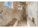Luxurious walk-in shower features travertine tile, a built-in bench, and dual shower heads at 7340 West Dr, Wesley Chapel, FL 33544
