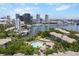 Waterfront view featuring downtown buildings, boats, and a community pool nestled among lush trees and modern condominium buildings at 736 Coral Reef Dr, Tampa, FL 33602