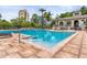 Community pool with lounge chairs, nearby clubhouse, and downtown buildings in background at 736 Coral Reef Dr, Tampa, FL 33602