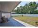 Large backyard featuring a covered patio and a white fence at 7657 Nottinghill Sky Dr, Apollo Beach, FL 33572
