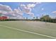 Outdoor basketball court, featuring well-maintained surfaces, multiple hoops and surrounded by green hedges and landscaping at 7657 Nottinghill Sky Dr, Apollo Beach, FL 33572