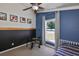 Well-lit blue bedroom featuring a bed, window views, and unique sports-themed decor at 7657 Nottinghill Sky Dr, Apollo Beach, FL 33572