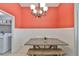 Bright dining area featuring a rustic wood table, bench seating, and stylish chandelier lighting fixture at 7657 Nottinghill Sky Dr, Apollo Beach, FL 33572