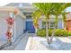 Inviting entryway with blue double doors, white stone landscaping, and tropical plants at 7657 Nottinghill Sky Dr, Apollo Beach, FL 33572