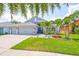 Charming home featuring well-manicured lawn, lush tropical landscaping and a three car garage at 7657 Nottinghill Sky Dr, Apollo Beach, FL 33572