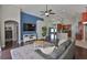 Open-concept living room with a large sectional sofa, hardwood floors, and seamless flow to the kitchen at 7657 Nottinghill Sky Dr, Apollo Beach, FL 33572