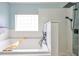 Main bathroom boasts a soaking tub with wooden tray, white subway tile, and rainfall shower at 7657 Nottinghill Sky Dr, Apollo Beach, FL 33572