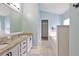 Main bathroom featuring double vanity, tiled floors, soaking tub, and access to the walk-in closet at 7657 Nottinghill Sky Dr, Apollo Beach, FL 33572