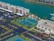 Aerial view showcasing tennis courts, boat docks, parking, and waterways that complement property at 7665 Sun Island S Dr # 307, South Pasadena, FL 33707