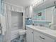 Bright bathroom featuring white vanity, a cabinet, and a shower with a lace curtain at 7665 Sun Island S Dr # 307, South Pasadena, FL 33707