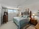 Cozy bedroom features a bed with a patterned blue quilt, and a tv on an antique cabinet at 7665 Sun Island S Dr # 307, South Pasadena, FL 33707