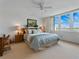 Bright bedroom featuring a bed with a light-patterned quilt, with a waterfront view from the window at 7665 Sun Island S Dr # 307, South Pasadena, FL 33707