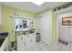Charming kitchen pass-through, complemented by bright lighting and featuring modern white appliances, creating an inviting space at 7665 Sun Island S Dr # 307, South Pasadena, FL 33707