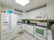 Well-lit kitchen featuring white appliances and cabinets, complete with modern amenities for culinary enthusiasts at 7665 Sun Island S Dr # 307, South Pasadena, FL 33707