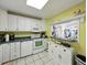 A bright kitchen with bar pass-through, featuring white appliances and tile floor, seamlessly connects to other living spaces at 7665 Sun Island S Dr # 307, South Pasadena, FL 33707