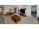 Bright living room featuring a wooden coffee table, entertainment center, and dining area with a water view through the kitchen at 7665 Sun Island S Dr # 307, South Pasadena, FL 33707
