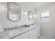 Bright bathroom featuring a double vanity with granite countertops and decorative gold-trimmed mirrors at 7991 1St S Ave, St Petersburg, FL 33707