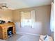 Bedroom features a rolltop desk, ceiling fan, and window with white curtains, offering a cozy workspace at 810 Bluewater Dr, Sun City Center, FL 33573