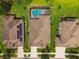 Aerial view of the home highlighting the screened pool, patio, and well-maintained yard in a residential neighborhood at 8320 Bluevine Sky Dr, Land O Lakes, FL 34637