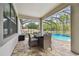 Relaxing covered patio boasts a dining area with seating and views of the refreshing screened pool at 8320 Bluevine Sky Dr, Land O Lakes, FL 34637