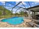 Beautiful pool with brick pavers and comfortable outdoor seating and screened-in enclosure at 8320 Bluevine Sky Dr, Land O Lakes, FL 34637