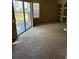 A carpeted living room featuring a sliding glass door and built in shelving at 8517 Island Breeze Ln # 106, Temple Terrace, FL 33637