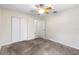 Neutral bedroom with ceiling fan, plush carpet, and white closet doors at 8696 118Th St, Seminole, FL 33772