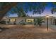 Charming single-story home with a well-lit yard and lush landscaping at twilight at 8696 118Th St, Seminole, FL 33772