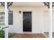 Inviting front entrance with a classic black door, tiled entryway, and decorative accents at 8696 118Th St, Seminole, FL 33772