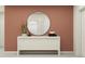 Entryway with modern white console table, round mirror, and minimal decor against a peach-colored wall at 10290 Purple Leaf Ct, Riverview, FL 33578